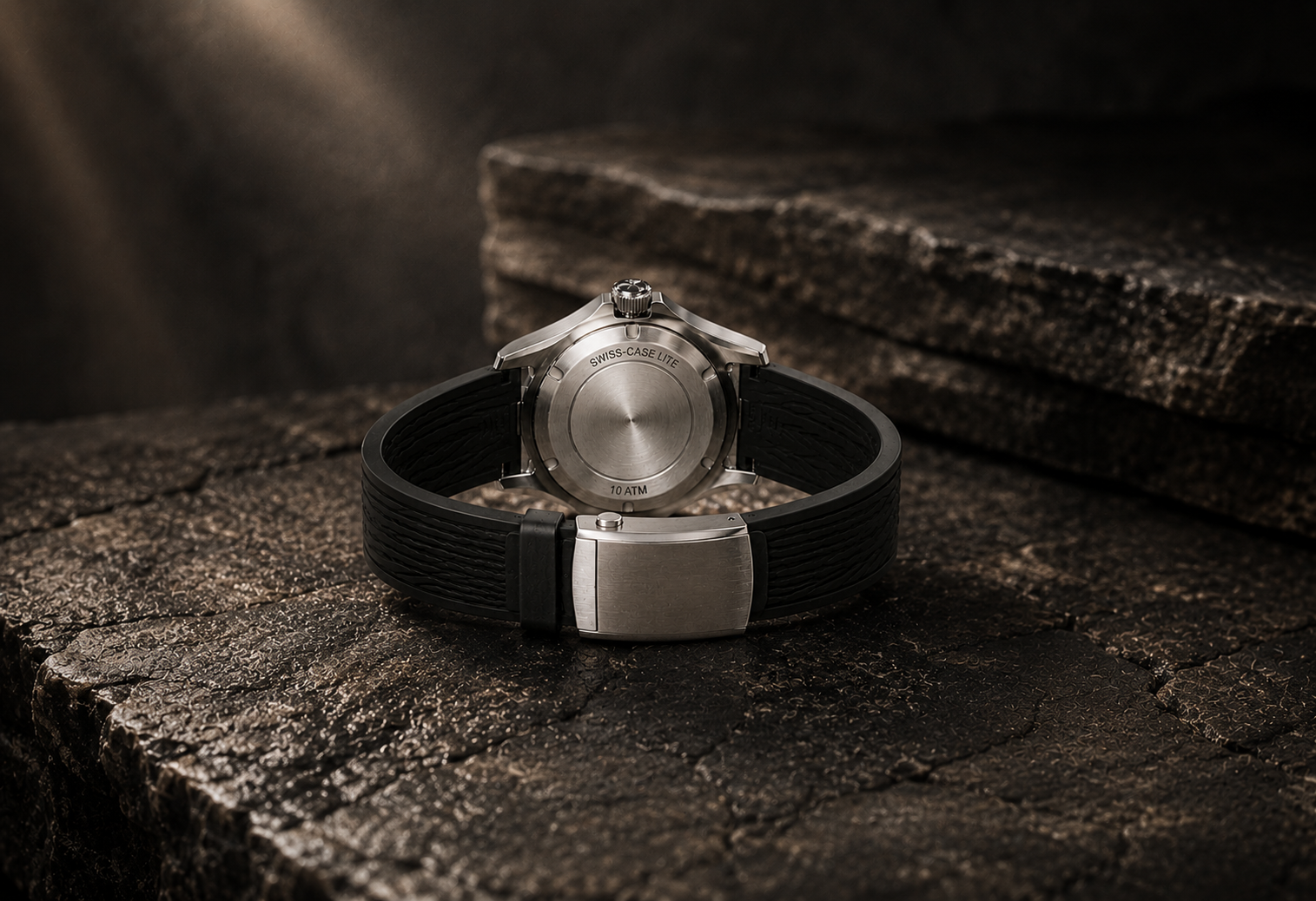 Swiss-case Lite case-back in brushed 316L steel, engraved 10 ATM, resting on dark stone